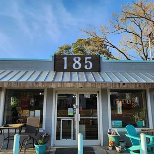 the front of a restaurant with tables and chairs