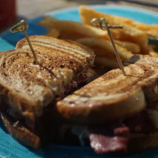a blue plate with a sandwich and french fries