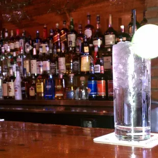 a tall glass with a lime in it