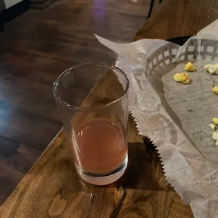 a glass of wine and a tray of popcorn