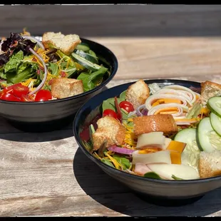 two bowls of salad and bread