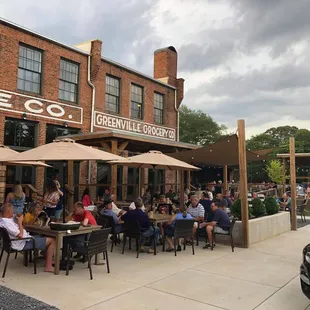 people sitting at tables outside of a restaurant