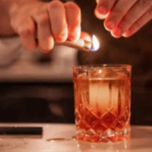 a person lighting a glass with a lighter