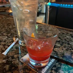 a cocktail and a glass of water