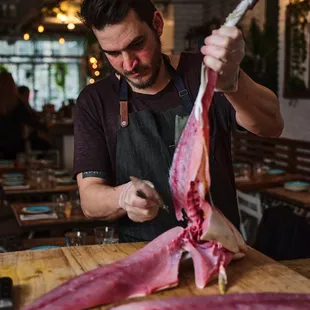 a butcher cutting a piece of meat