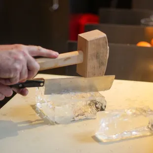 a man chopping ice with a hammer
