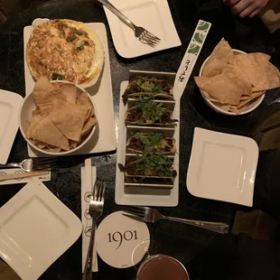 a table with plates of food and utensils