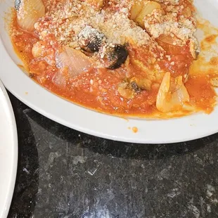 a plate of pasta with olives and cheese