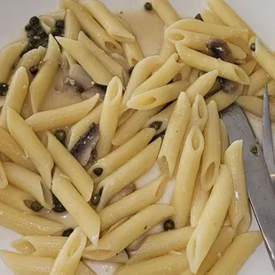 a plate of pasta with mushrooms and capers