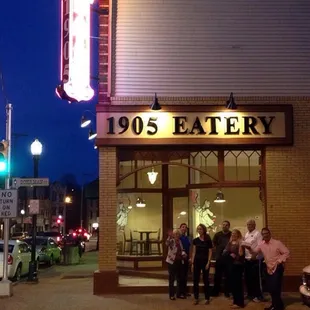 people standing outside of the restaurant