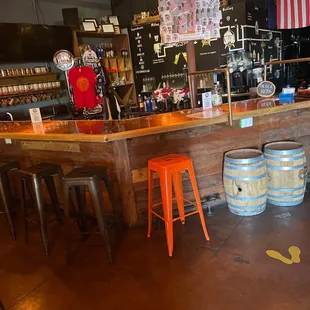 a bar with stools and barrels