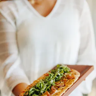 a woman holding a pizza