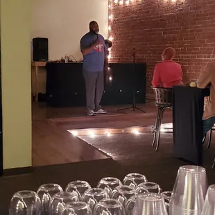 a man standing in a room full of empty wine glasses