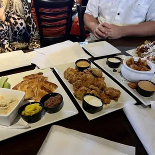 a man and a woman sitting at a table with plates of food