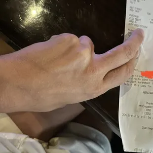 a hand pointing at a receipt