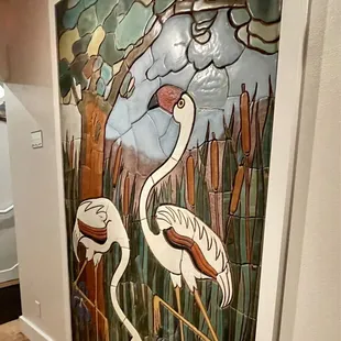 a painting of two flamingos
