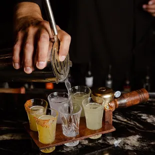 a bartender pouring a drink at a bar