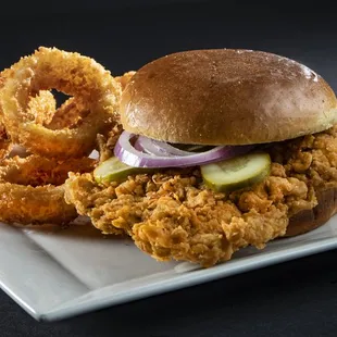 a fried chicken sandwich and onion rings