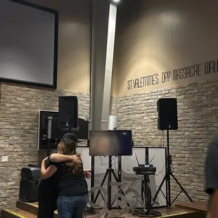 a couple of people hugging in front of a stage