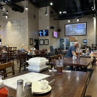 a restaurant with tables, chairs, and televisions