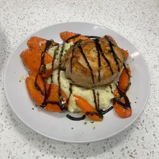 Frenched Pork Chop with a bourbon Glaze on top of a bed of mashed potato's and carrots