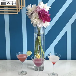 a vase of flowers and two martinis
