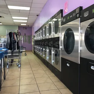 Wall of newer commercial dryers. They appear to be well maintained.