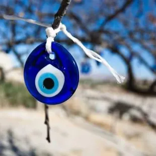 a blue evil eye hanging from a tree