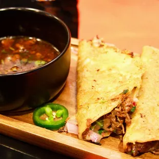 a bowl of soup and a tortilla