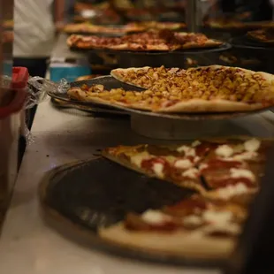 a variety of pizzas on display