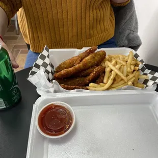 Pan fried chicken tenders with crispy fries.