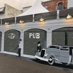 an old car parked in front of a pub
