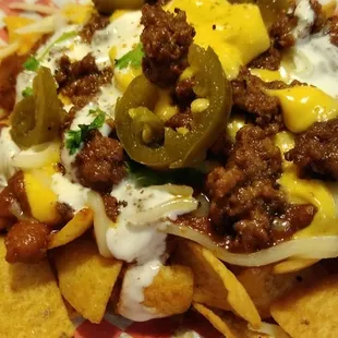 Piggy Pie. chopped brisket, homemade chili, sour cream, gords secret sauce, cheese sauces n jalapeños..