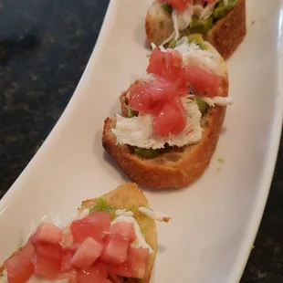 Crab Crostini topped with avacado and tomatoes