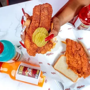 a person holding a fried chicken sandwich