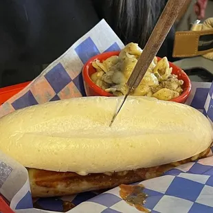 a sandwich in a basket with a knife