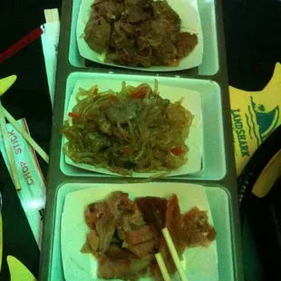 three plates of food with chopsticks