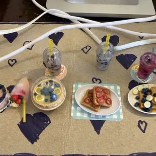 a table setting with a laptop and various desserts