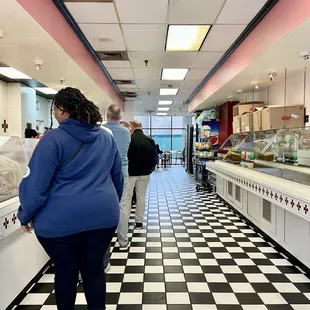 a woman in a blue jacket and a man in a black and white checkered floor