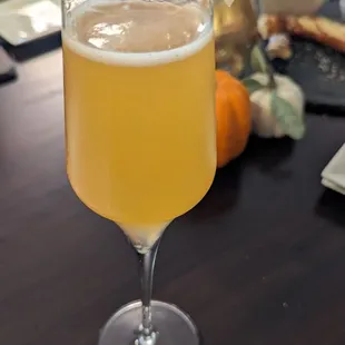 a glass of beer with a slice of apple on the rim