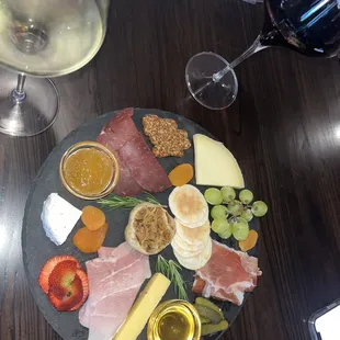a platter of cheese, meat, and fruit