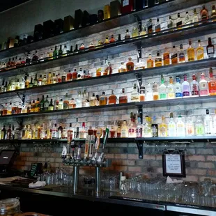 a wall of liquor bottles in a bar