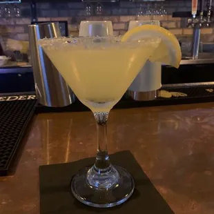 a cocktail in a martini glass on a bar