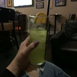 a person holding a glass of lemonade