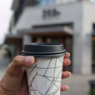 a hand holding a coffee cup