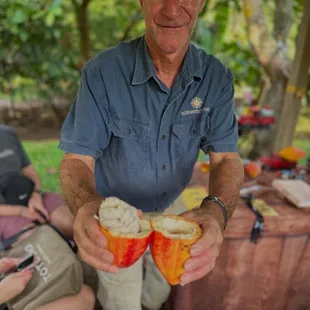Co-owner, Michael, with a freshly opened pod for tasting.  The white outside covering tastes like Lilikoi or passion fruit to me.