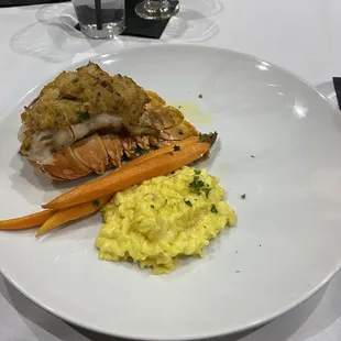 Crab stuffed lobster tail with risotto and carrots.