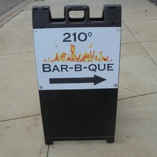 Placard sign on the sidewalk - follow the arrow to the front door.