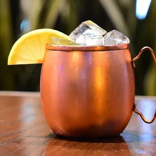 a copper mug with ice and a lemon wedge