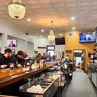 a busy bar with people sitting at the bar